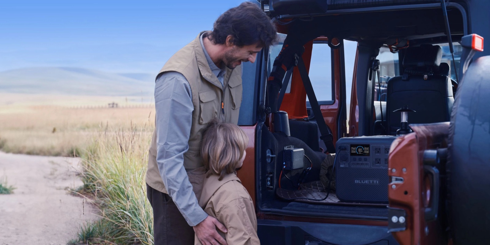 Man and child at the open rear of a camper van