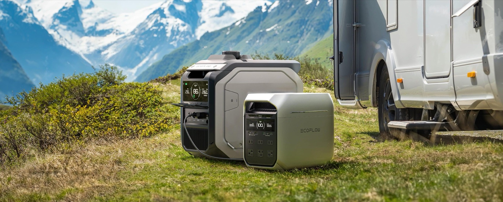 Two power stations set up on grass beside a motorhome