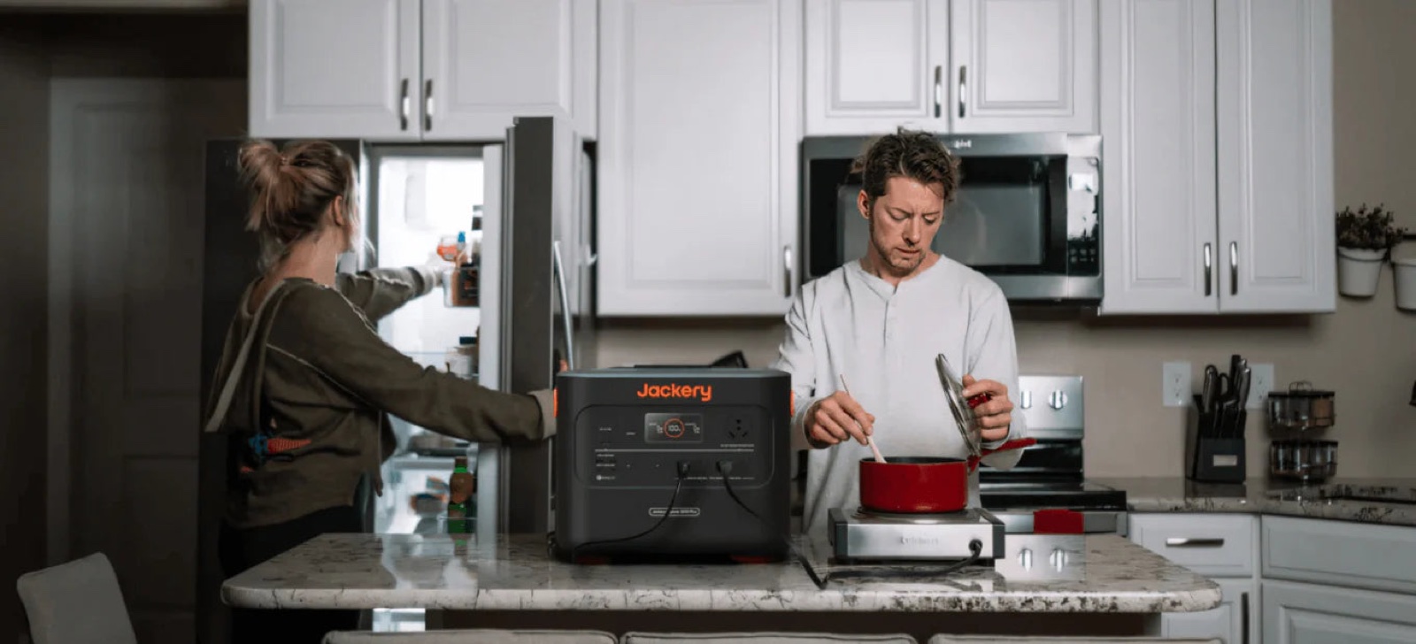 Couple cooking on a portable hob powered by a battery unit